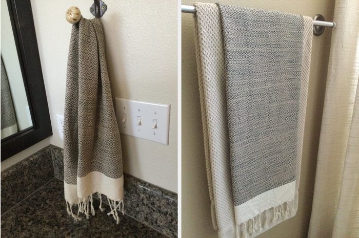 Reviewer image of a white and gray fringed hand towel hanging from hooks