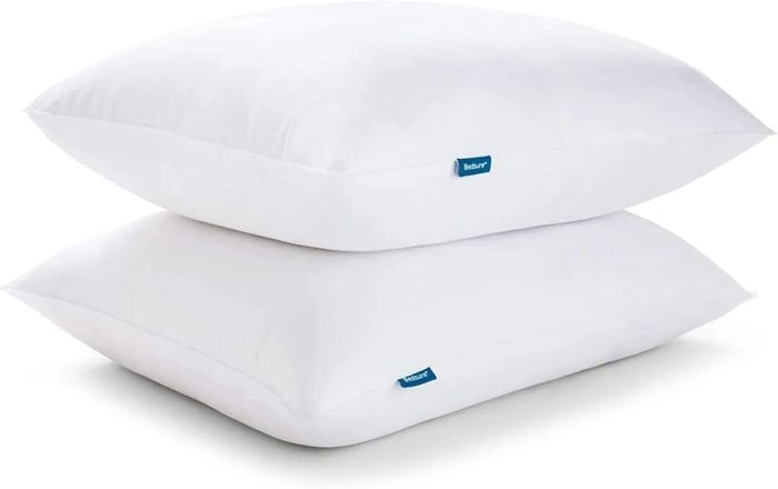 Two stacked pillows with small blue tags on the sides, perfect for adding both comfort and style to your bedroom.