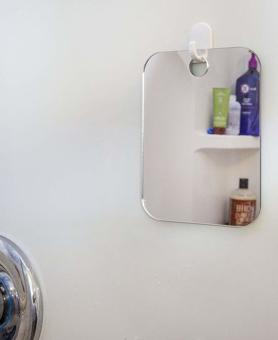 A shower surround featuring a small mirror attached to the wall