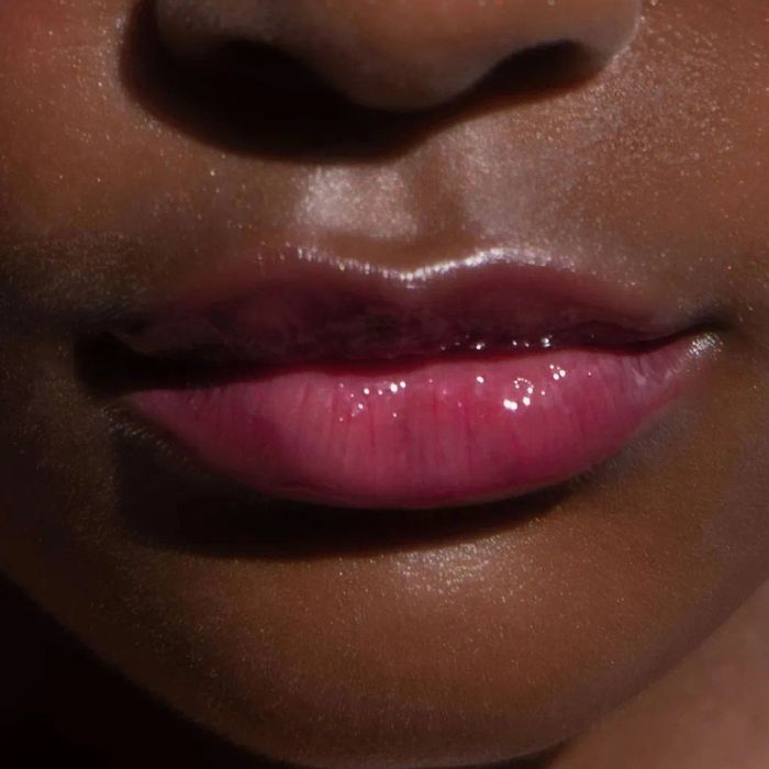 A close-up of a model wearing an ultra-pigmented pink lip gloss.