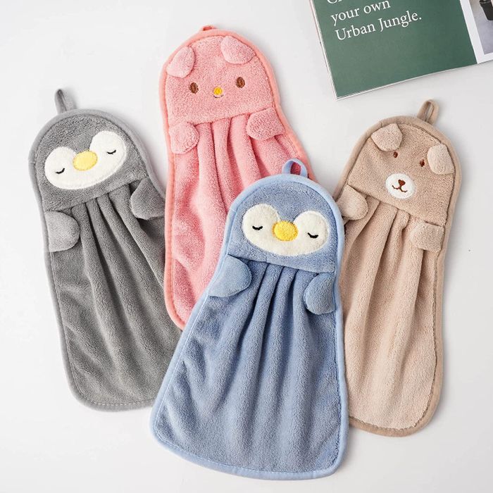 Hand towels shaped like penguins, pigs, and bears displayed on a white countertop
