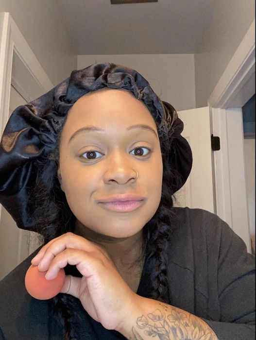 A reviewer showing their face with foundation perfectly blended using the sponge.