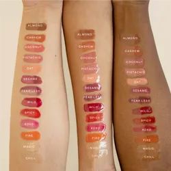 A model's arms showcasing swatches of lip gloss.