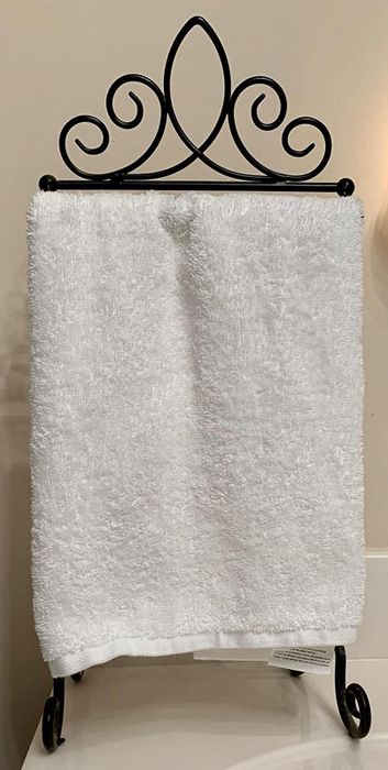 Image from a reviewer showing a white hand towel neatly folded on a sleek black metal towel rack