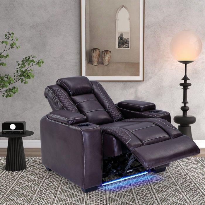A sleek, modern recliner with a quilted design, an extended footrest, and built-in cup holders, making it the ideal choice for a stylish living space.