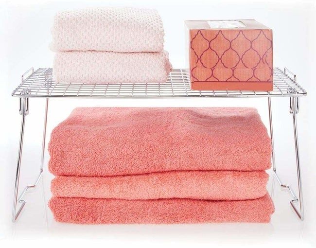 Open stainless steel shelf with towels neatly arranged on it