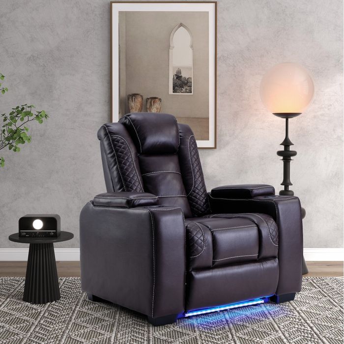 A recliner chair equipped with cup holders and blue LED lighting at its base, complemented by a side table with a speaker and a lamp, all set in a modern living room ambiance.