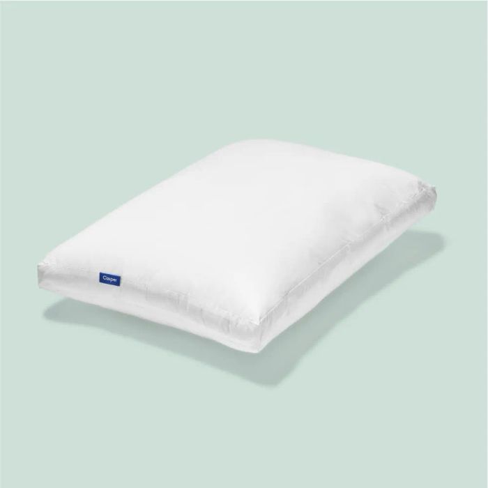 A Casper pillow shown, fluffy with a small blue tag on the side.