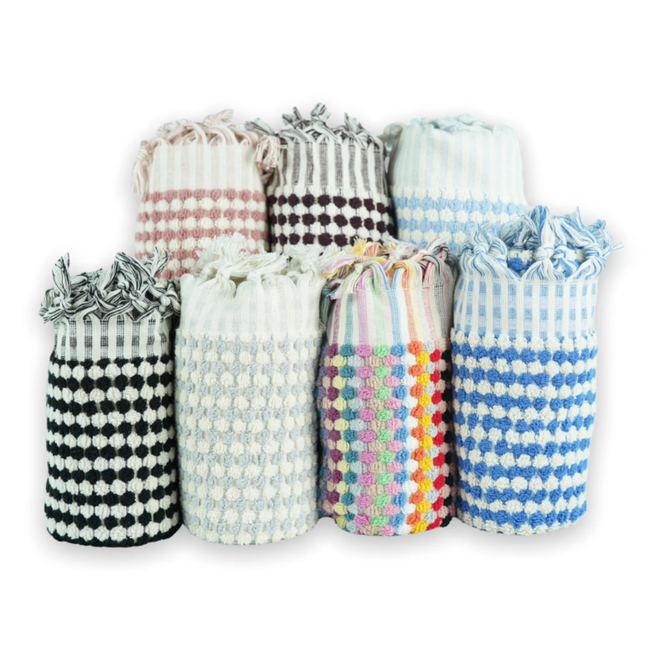 Seven rolled checkered hand towels in pink, purple, light blue, black, gray, rainbow, and dark blue, set against a crisp white background