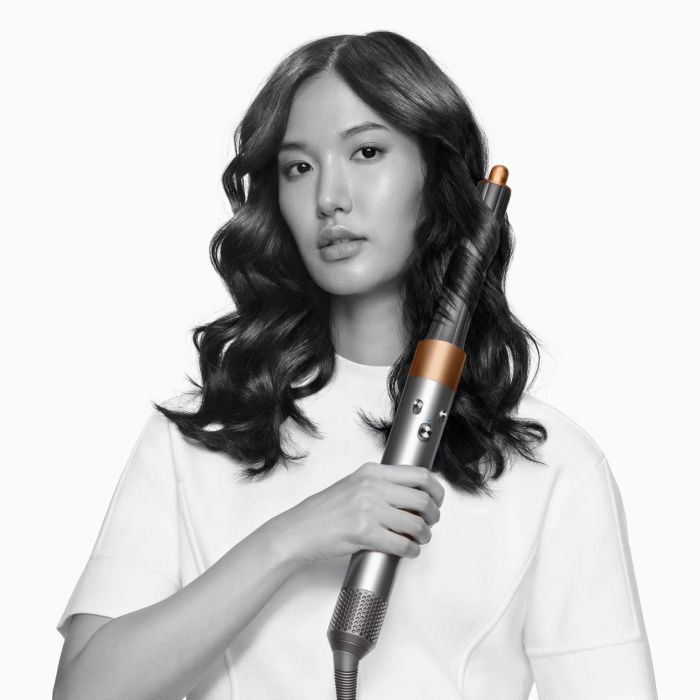 A model styling their hair with the Dyson Airwrap