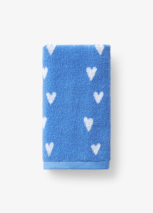 Blue towel adorned with white heart shapes on a white backdrop