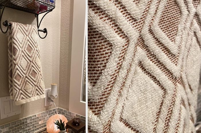 A close-up of a brown and white diamond-patterned hand towel hanging on a towel rack