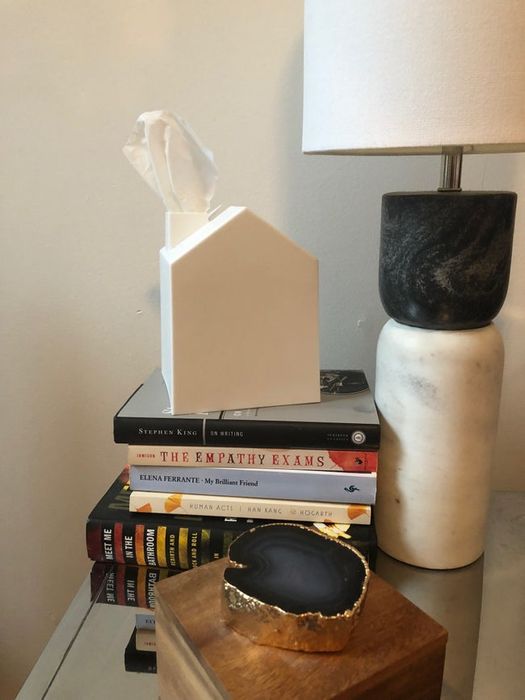 The tissue box covers resting on a stack of books