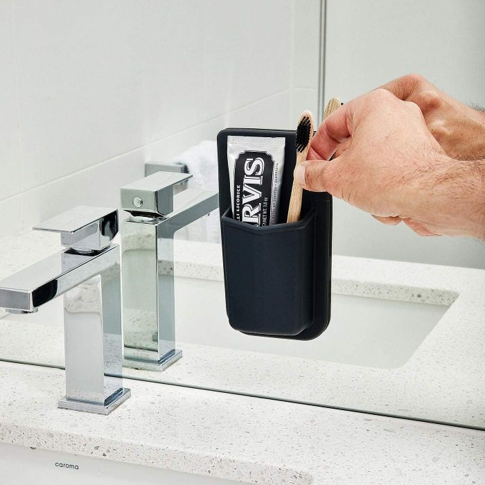 A toothbrush holder attached to a mirror