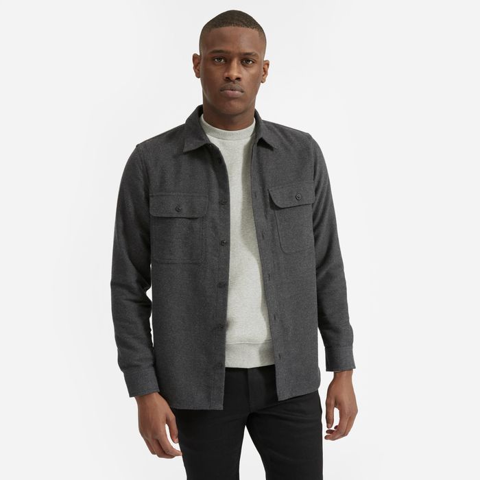A model is wearing the button-down shirt with buttoned pockets on each side, shown in dark grey.
