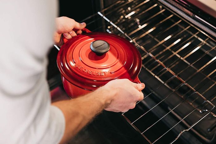The red circular pot with a lid and handles on both sides.