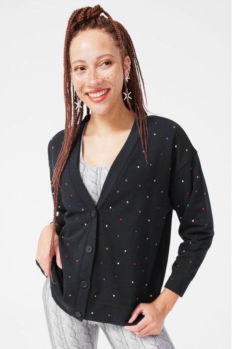 A model wearing a black cardigan adorned with small jewels all over it.