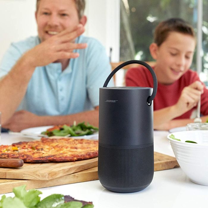 A black circular-shaped speaker with a handle on top.