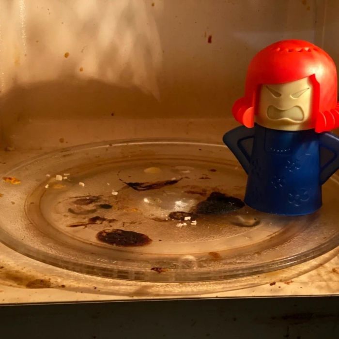 Reviewer’s photo showing the Angry Mom cleaner in a microwave covered in grime