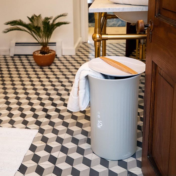 A round-shaped grey bin with a lid and wood handle, featuring a small screen on the front.