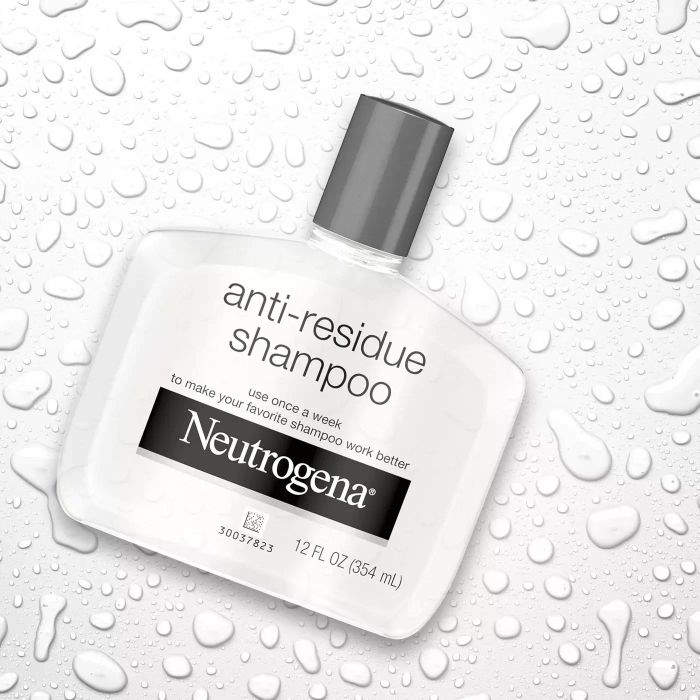 A bottle of Neutrogena anti-residue shampoo surrounded by water droplets
