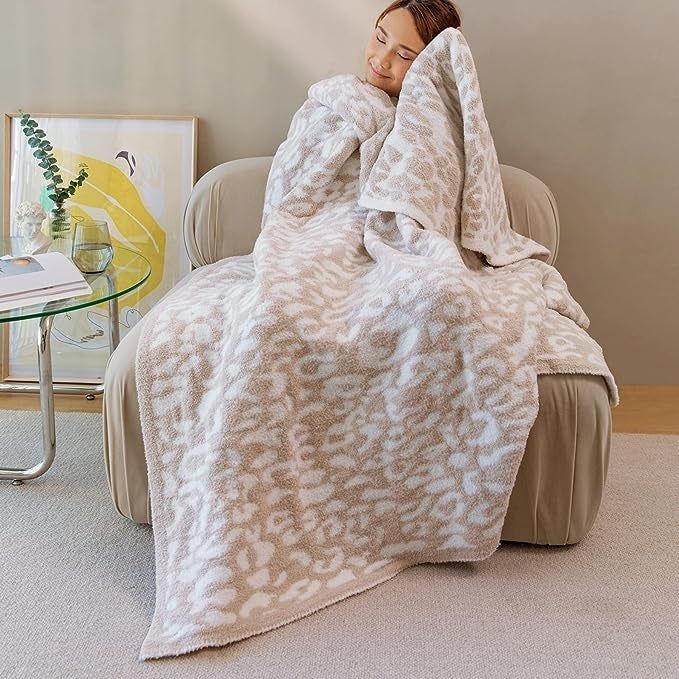 A model cuddling up in the beige and white throw blanket