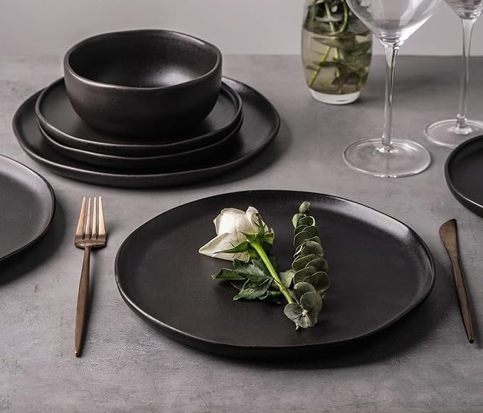 A matte black plate adorned with a delicate white rose design