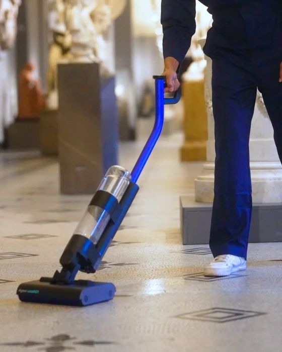 Person using a cordless vacuum on a tiled floor, emphasizing its sleek, lightweight design perfect for quick and easy cleaning