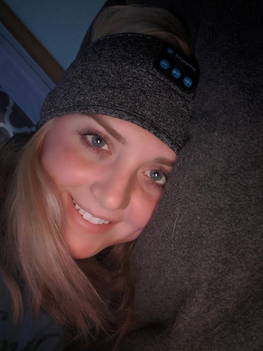 Reviewer wearing the grey headband, resting their head on a pillow