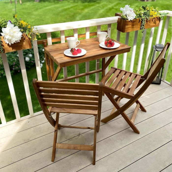 A wooden balcony table paired with two chairs