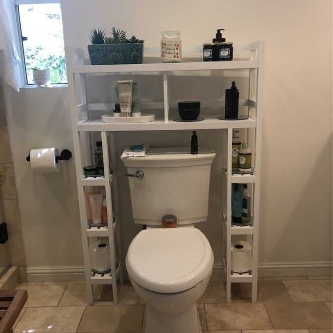 A reviewer photo of the white over-the-toilet storage shelf in a bathroom