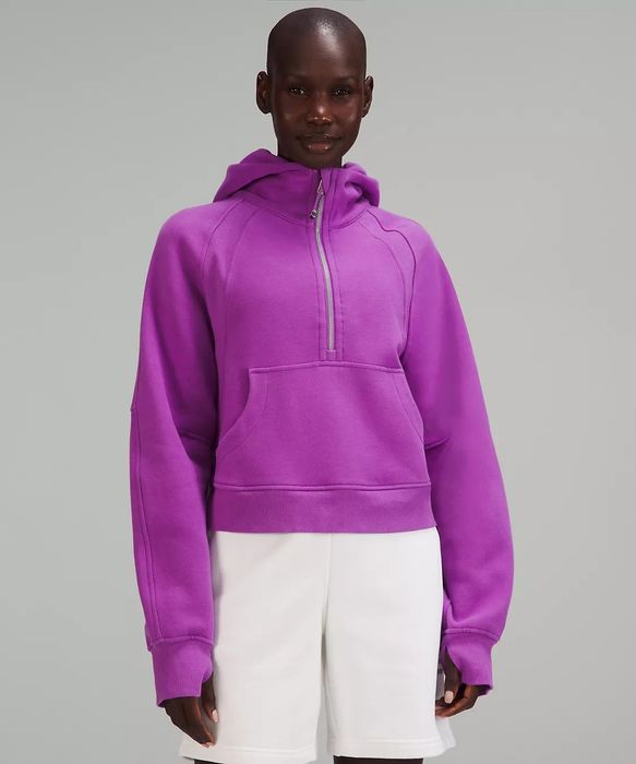 A model is seen wearing the hoodie in a vibrant purple shade.