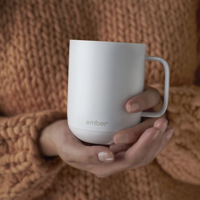 A model is holding the elegant gold mug.