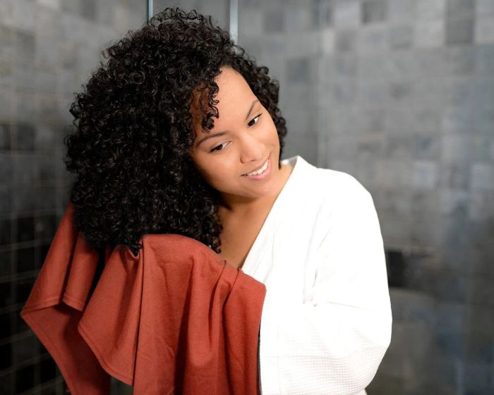 A model scrunching their curls with the same t-shirt hair towel