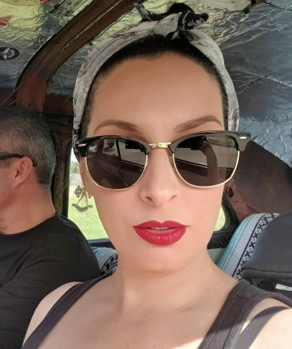 A reviewer wearing bold red lipstick, looking confident and stylish.