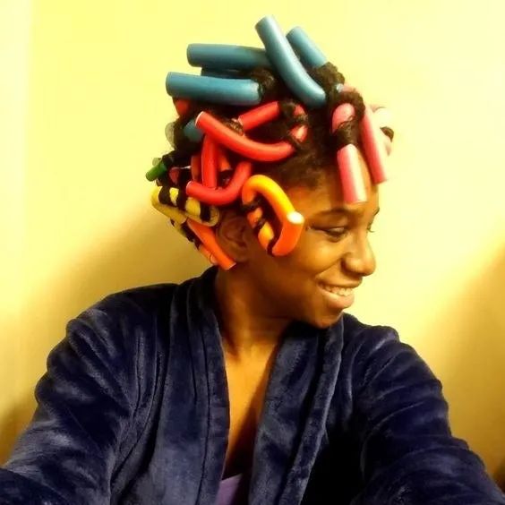 A reviewer with foam rods in their hair