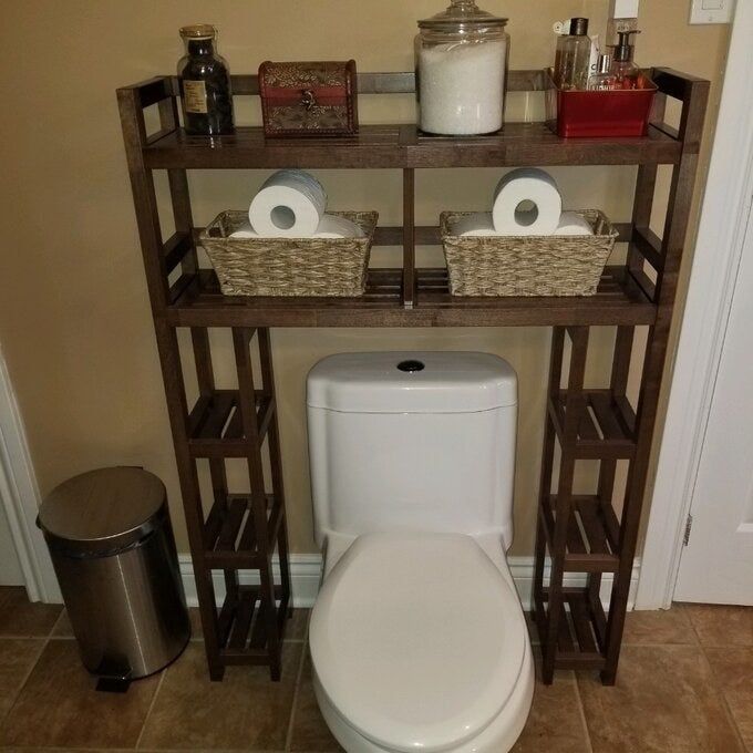 A reviewer photo showing the brown over-the-toilet storage shelf in a bathroom