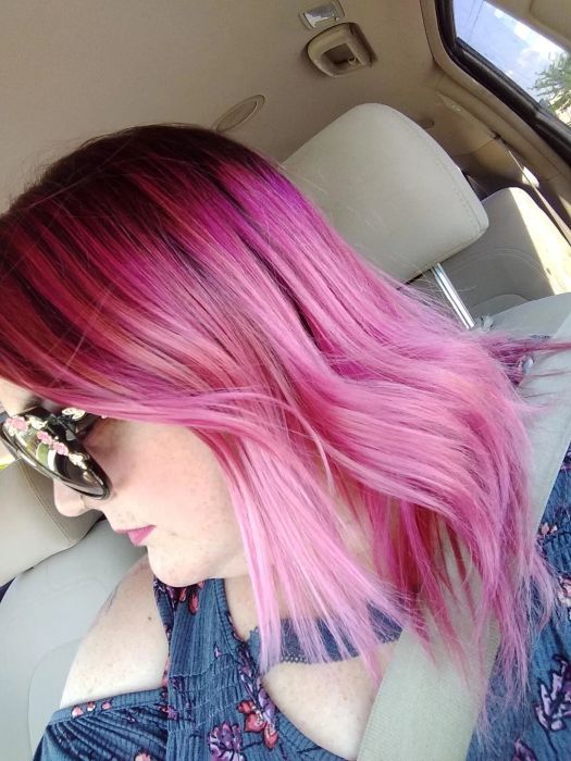 A reviewer sporting shiny, pink-dyed hair.