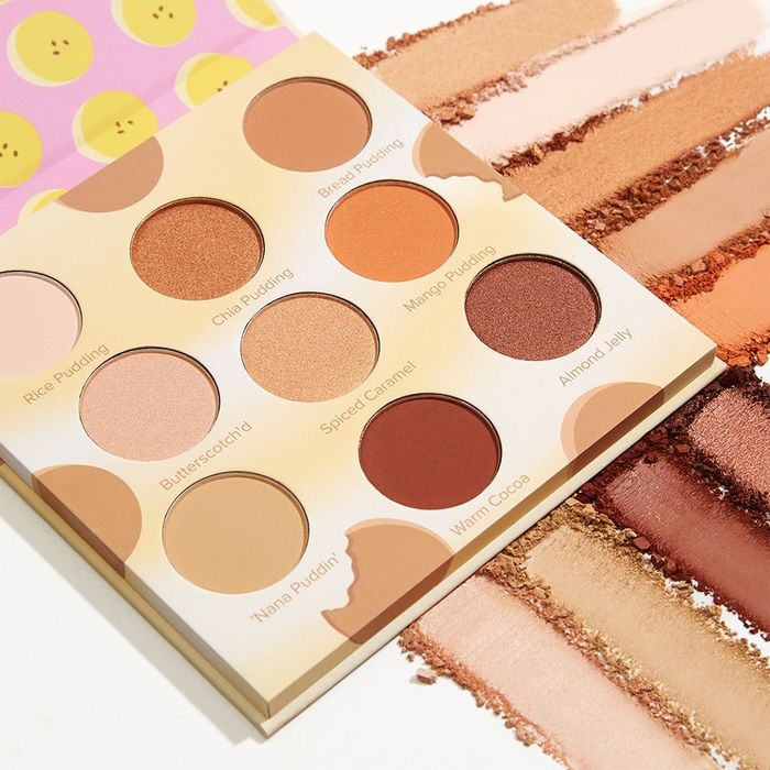 A diverse eyeshadow palette featuring a variety of neutral shades, with swatches of the colors displayed beside it