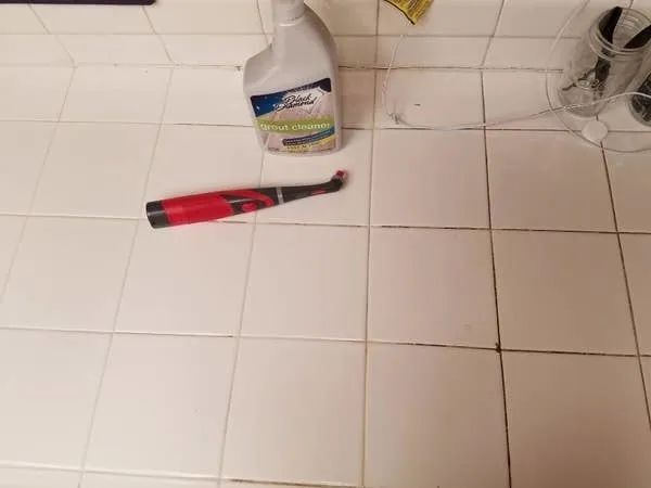 A reviewer’s photo showing one half of their tile floor with dirty grout, and the other half completely spotless