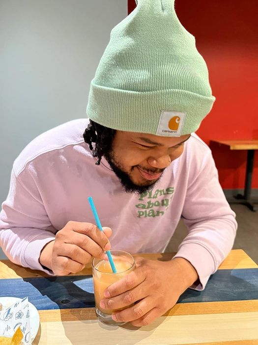 A person wearing a mint-colored Carhartt winter beanie
