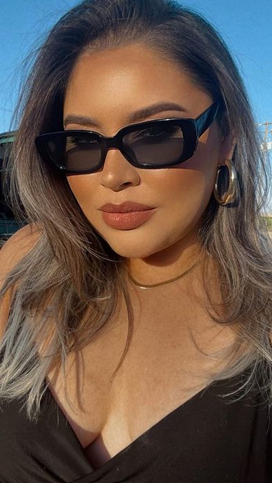 a reviewer rocking black sunglasses outdoors