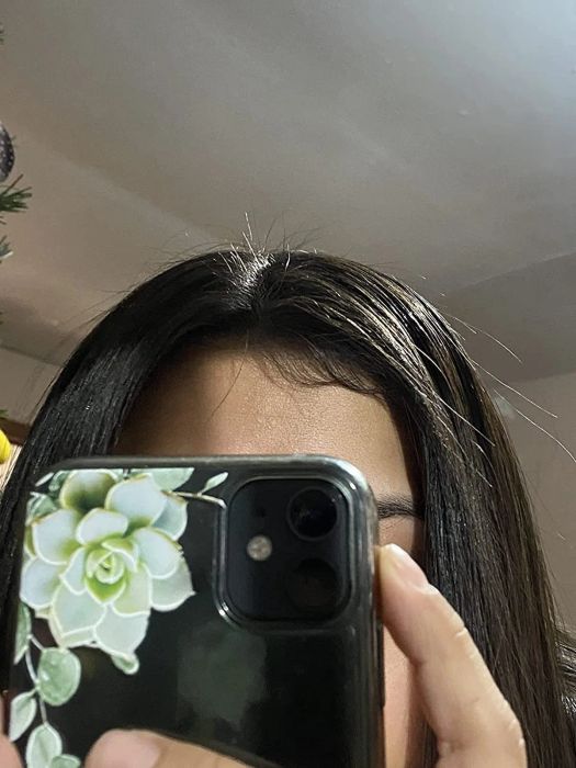 An after photo showing the same reviewer with their flyaways neatly tamed and sleek hair