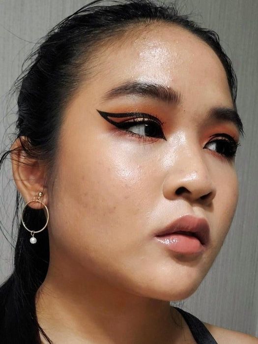 A reviewer showcasing a unique eyeliner design