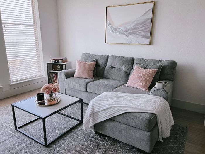 A square faux-marble coffee table placed in front of a reviewer's sofa