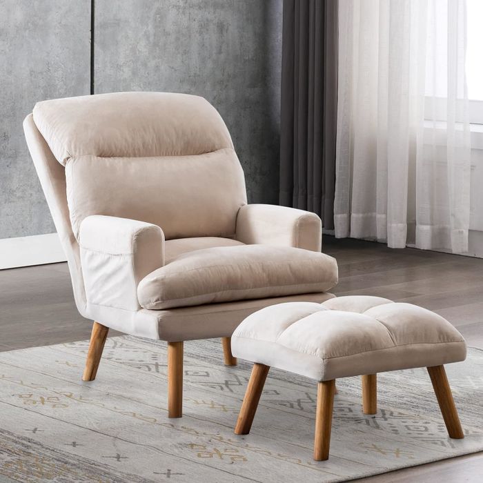 A modern living room setting showcasing an armchair with a matching ottoman, ideal for shopping purposes
