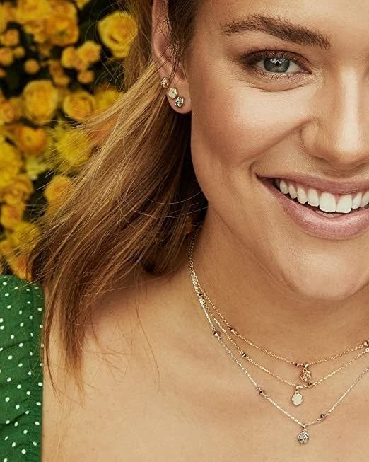 A model wearing several pairs of stud earrings in her ears