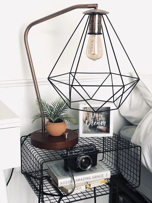 A close-up shot of a reviewer's black end table, styled with plants and books