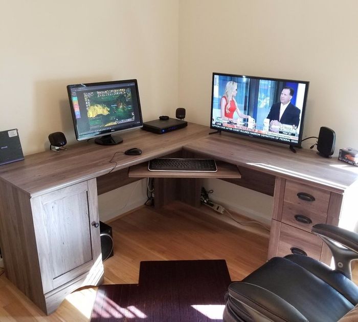 A reviewer’s workspace with two computer monitors and office supplies on top of the desk