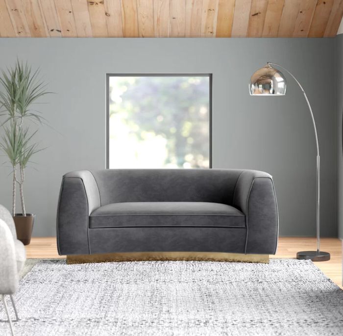 circular modern grey couch with a gold base